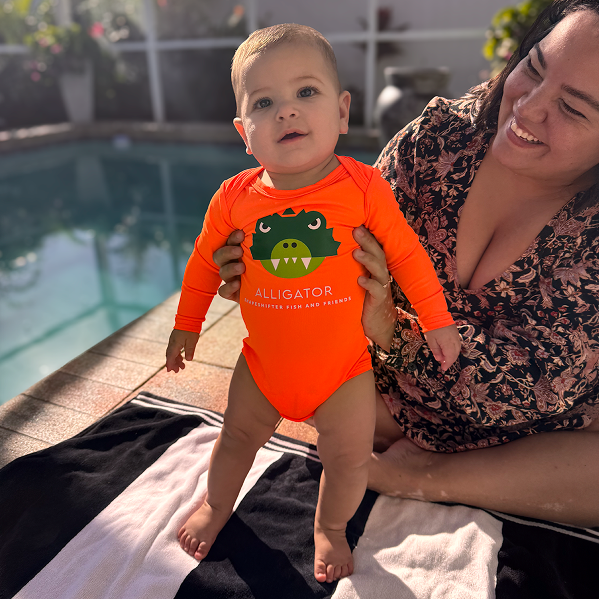 Baby wearing a Neon Orange Upf50 Sun Protective Baby Onesie by ShapeShifter Fish and Friends lifetsyle