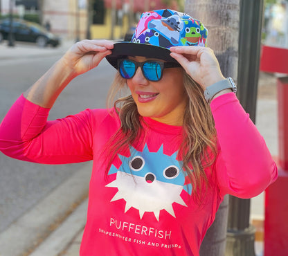 Woman wearing Reversible Fish And Friends Bucket Hat and pink pufferfish sun shirt by ShapeShifter Fish and Friends